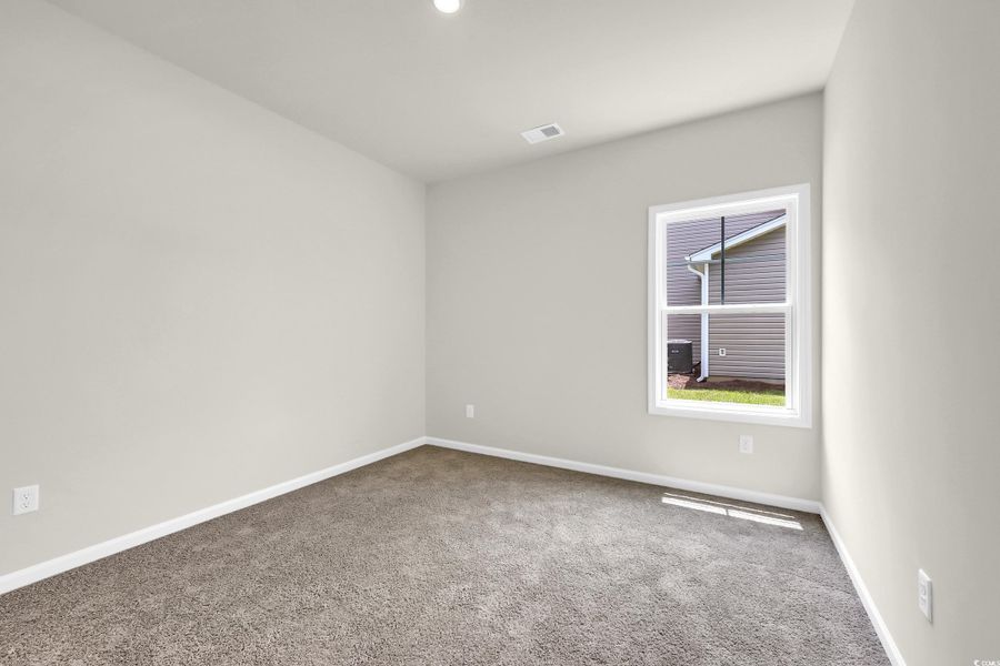 Spare room featuring carpet and baseboards