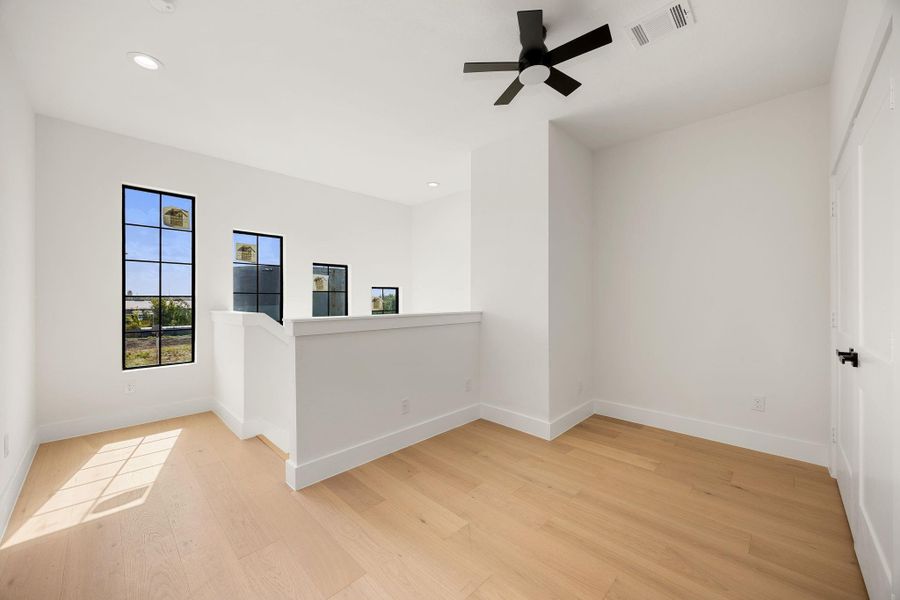 The third level offers a versatile flex area with a ceiling fan and convenient access to the utility room, providing additional space for a variety of needs.