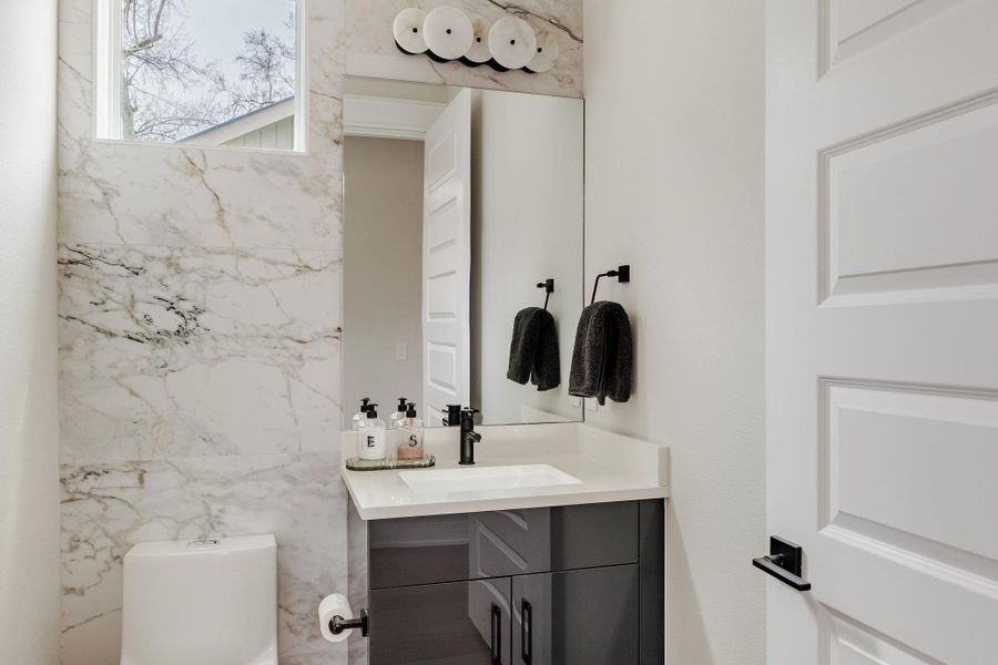 Half bathroom featuring vanity and toilet