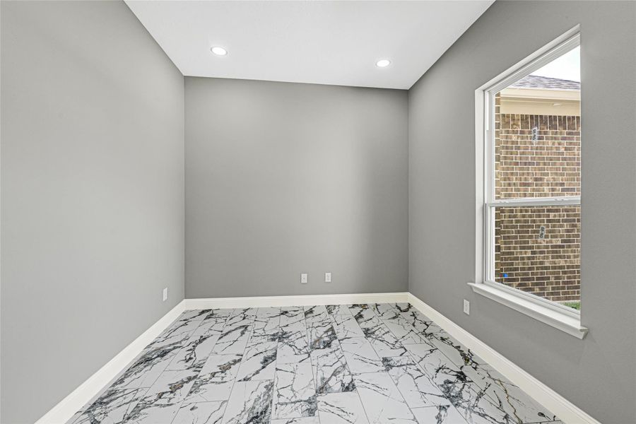 Office/study conveniently located as you enter the home. The room offers high ceilings, recessed lighting, and a large window providing lots of natural light. The floor is adorned with a stylish marble-patterned tile, offering a sleek and contemporary look. Office/study conveniently located as you enter the home. The room offers high ceilings, recessed lighting, and a large window providing lots of natural light. The floor is adorned with a stylish marble-patterned tile, offering a sleek and contemporary look.