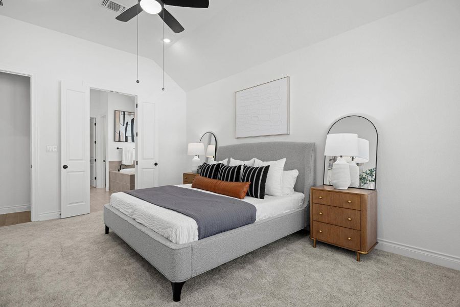 Bedroom with light colored carpet, vaulted ceiling, ensuite bath, a ceiling fan, and recessed lighting