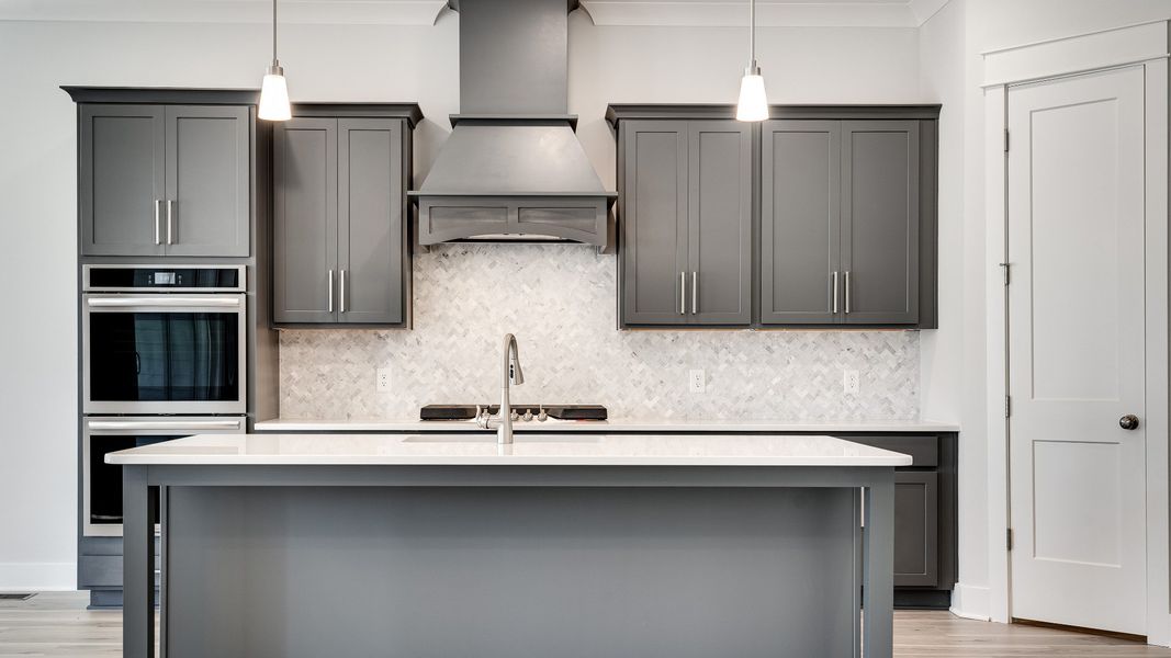 Modern kitchen with island, gray cabinets, and tile backsplash