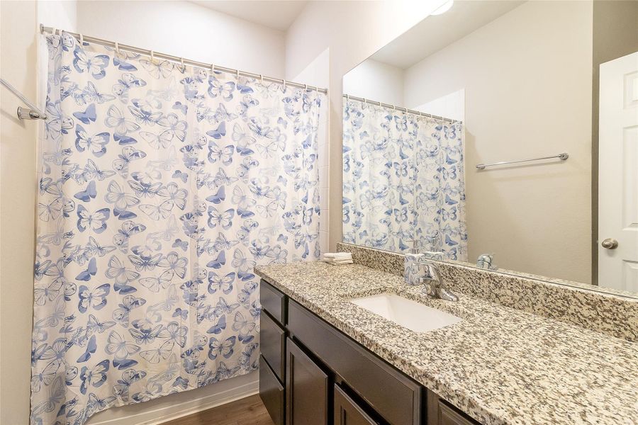 Granite counters and a vanity mirror complement this bathroom space.