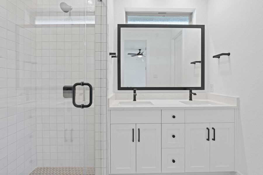 Bathroom featuring a stall shower and double vanity Bathroom featuring a stall shower and double vanity