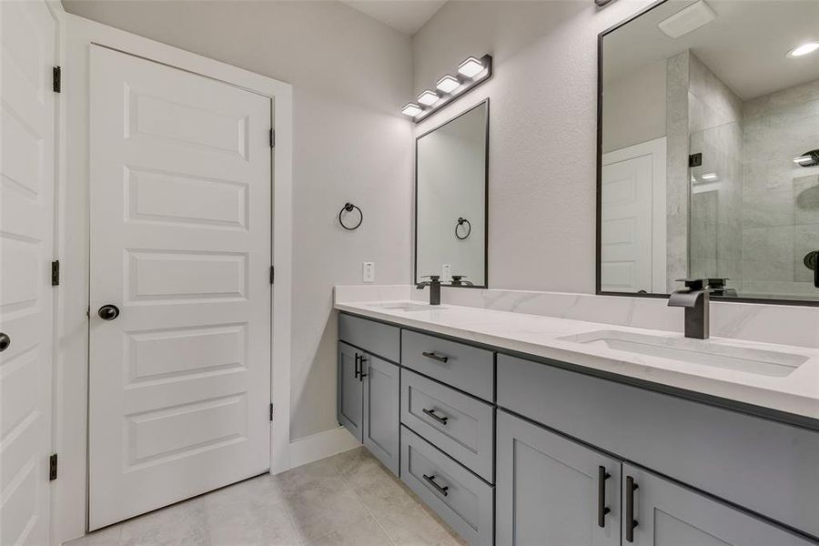 Primary Bathroom featuring double vanity and walk in closet Primary Bathroom featuring double vanity and walk in closet