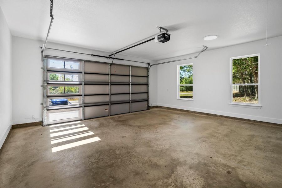 Garage with baseboards and a garage door opener
