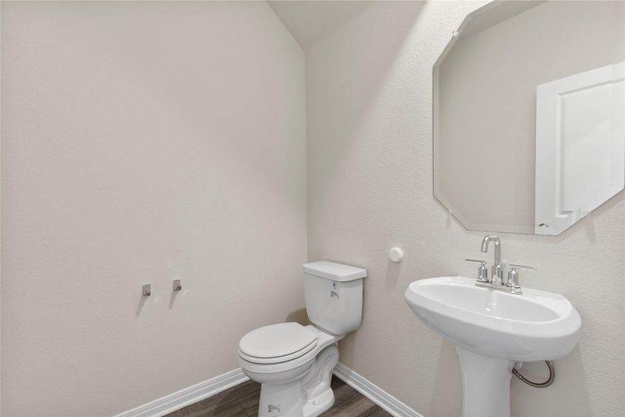 Half bath with dark wood-style flooring and a textured wall Half bath with dark wood-style flooring and a textured wall