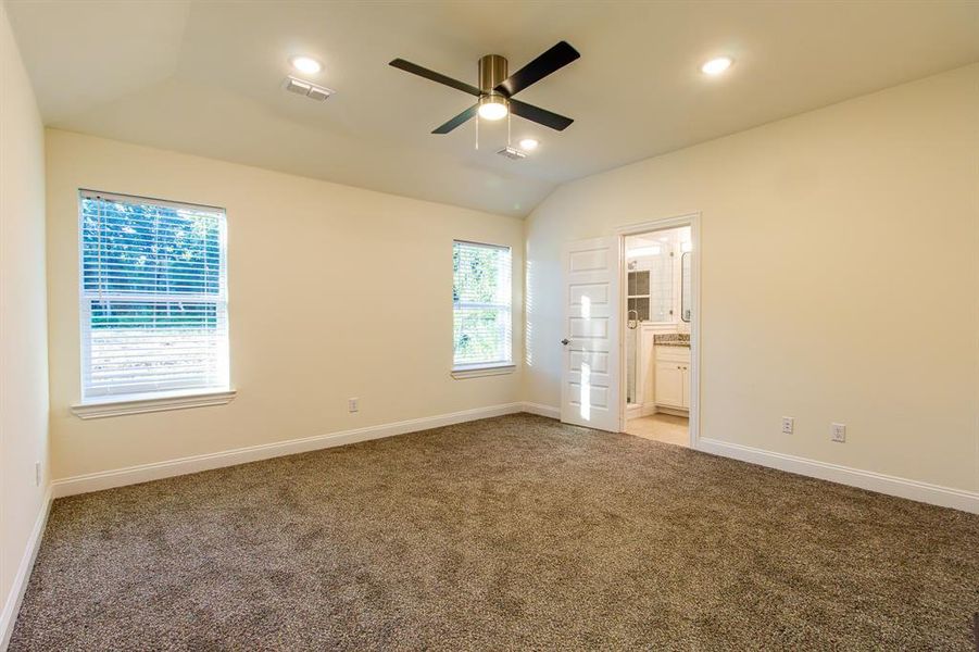Unfurnished bedroom featuring light colored carpet, lofted ceiling, recessed lighting, connected bathroom, and ceiling fan Unfurnished bedroom featuring light colored carpet, lofted ceiling, recessed lighting, connected bathroom, and ceiling fan