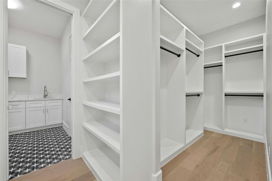 Walk in closet featuring sink and light hardwood / wood-style flooring