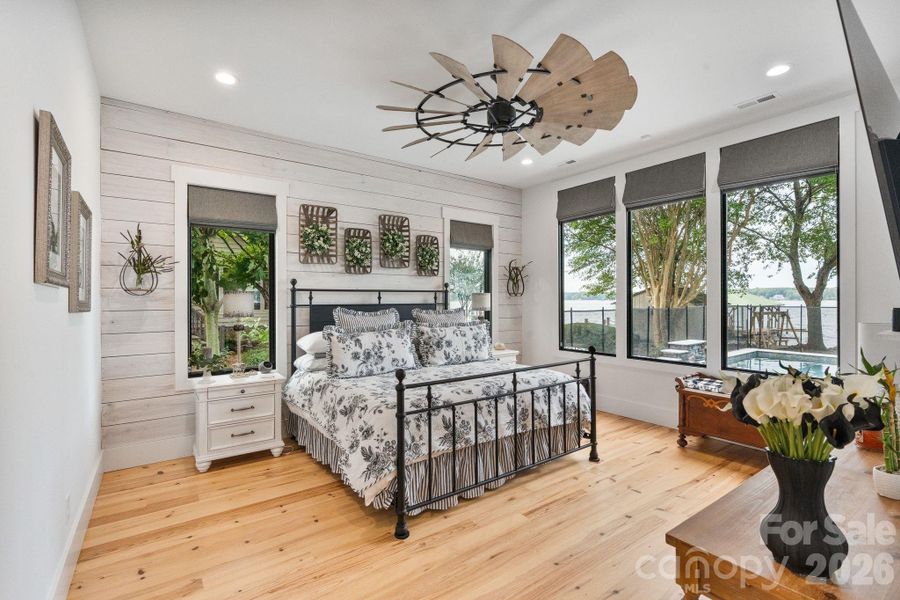 Spacious primary retreat on the main level offers a private sanctuary overlooking the water Spacious primary retreat on the main level offers a private sanctuary overlooking the water