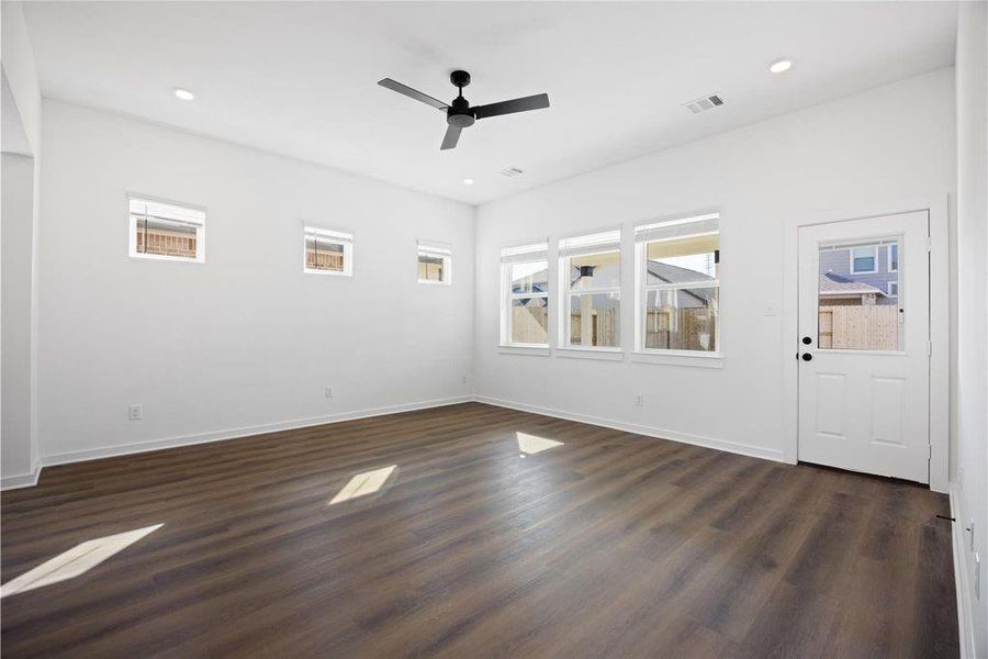 Bright, spacious living room with large windows, wood flooring, and a ceiling fan. Ideal for a living area with plenty of natural light and access to the outdoors. Large covered patio right outside Bright, spacious living room with large windows, wood flooring, and a ceiling fan. Ideal for a living area with plenty of natural light and access to the outdoors. Large covered patio right outside
