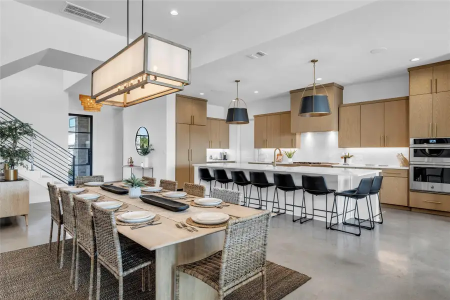 Gleaming concrete floors flow seamlessly throughout this open-concept culinary and dining space.