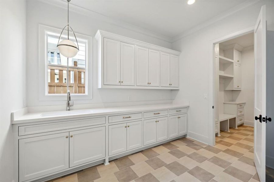 Oversized "working pantry" with second sink, quartz countertops, tremendous storage and access to the mud room and garage.