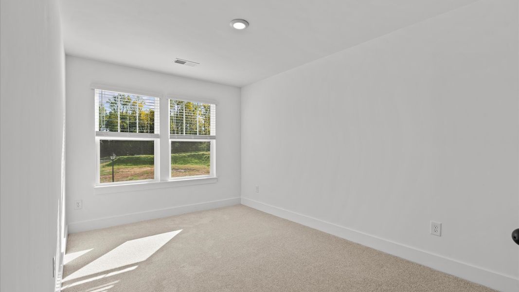 Accomplished design in this restful bedroom featuring plush carpet and oversized window views