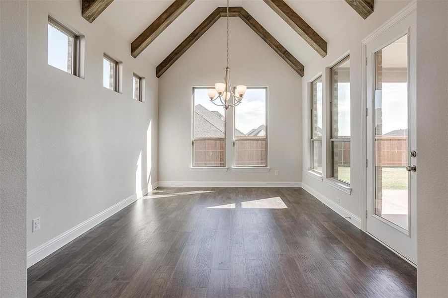 Unfurnished dining area with beamed ceiling, dark hardwood / wood-style flooring, and a healthy amount of sunlight