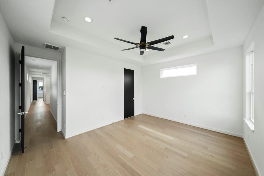 A sleek, airy bedroom with a modern ceiling fan and abundant natural light. A sleek, airy bedroom with a modern ceiling fan and abundant natural light.
