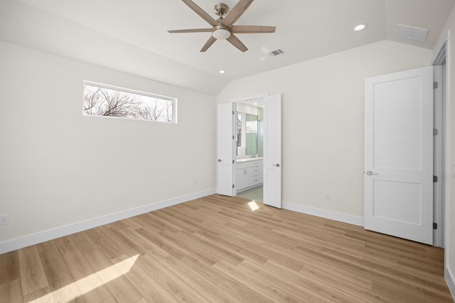 8' doors, recessed lighting, coffered ceiling, fan, light wood-type flooring, and connected bathroom
