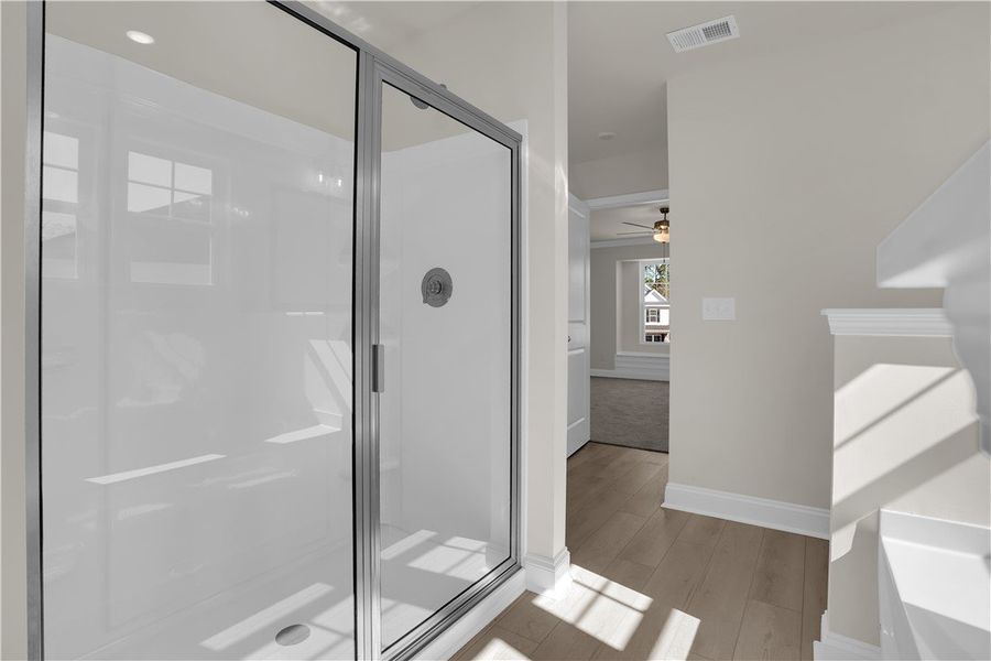 This bright bathroom features a sleek glass-enclos This bright bathroom features a sleek glass-enclos