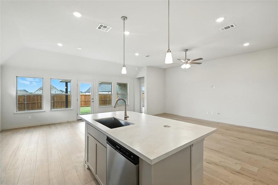 Kitchen featuring open floor plan, light countertops, dishwasher, light wood-type flooring, and recessed lighting Kitchen featuring open floor plan, light countertops, dishwasher, light wood-type flooring, and recessed lighting