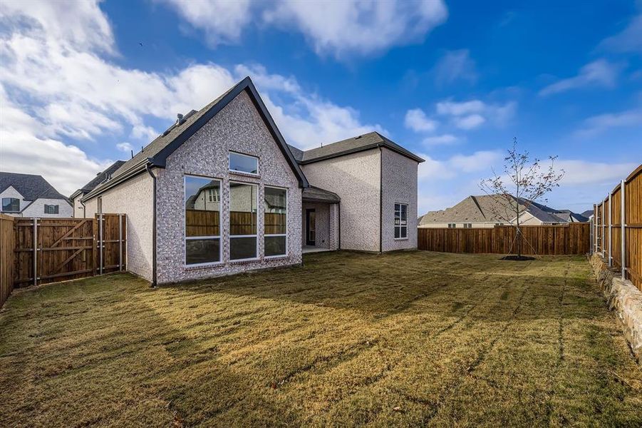 Rear view of house featuring a patio area, a fenced backyard, and a gate