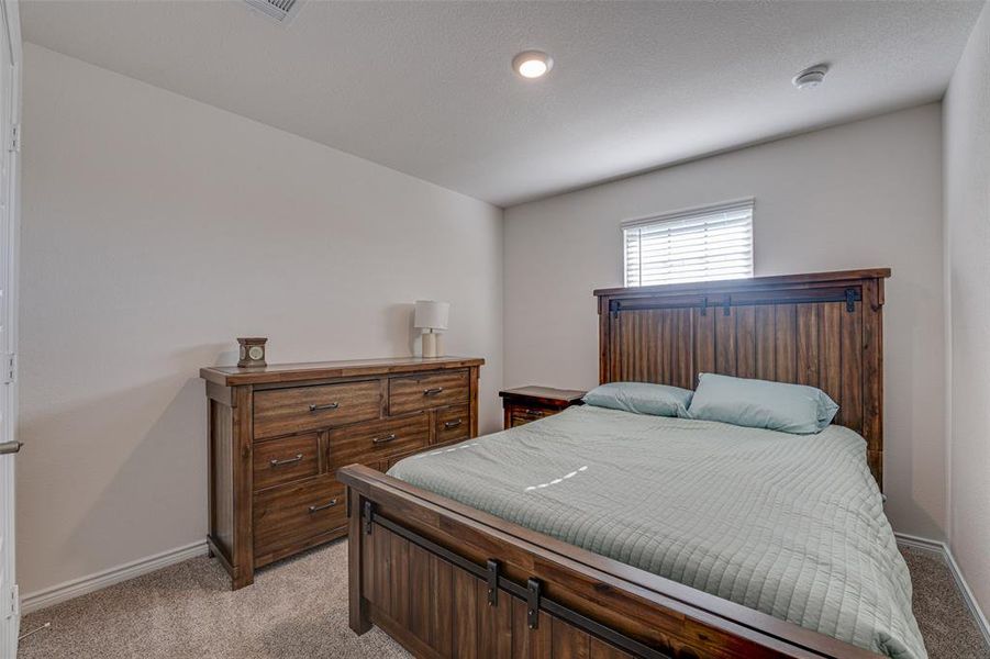 Bedroom featuring light colored carpet and baseboards
