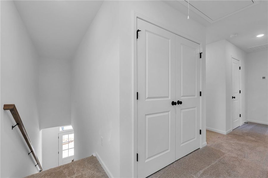 This interior hallway features carpet flooring and