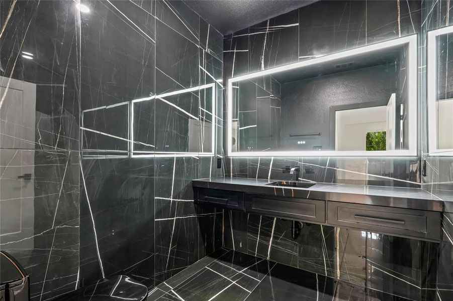 Full bath with vanity and a marble finish shower