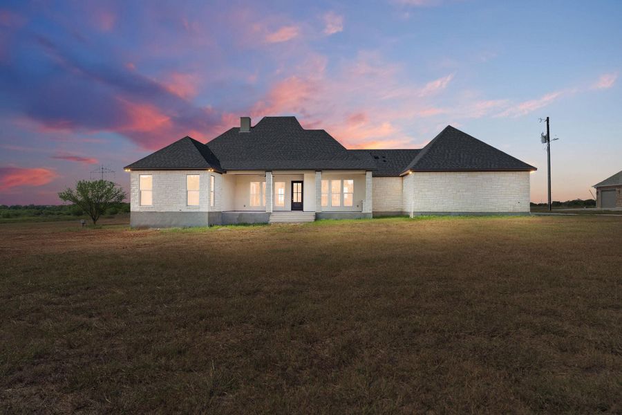 View of front facade featuring a yard, a shingled roof, and a chimney View of front facade featuring a yard, a shingled roof, and a chimney