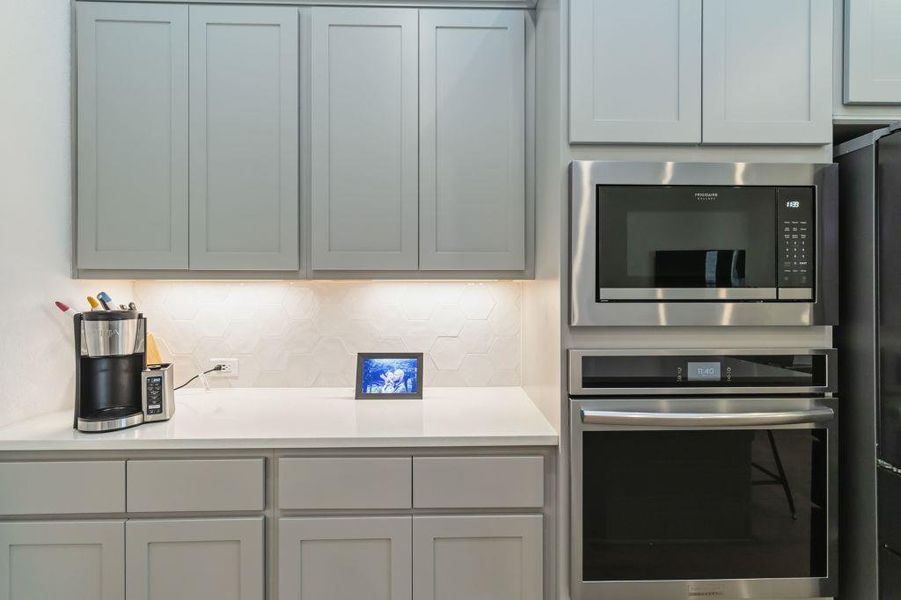 Modern kitchen with sleek cabinetry, a smooth countertop, and integrated stainless steel appliances.