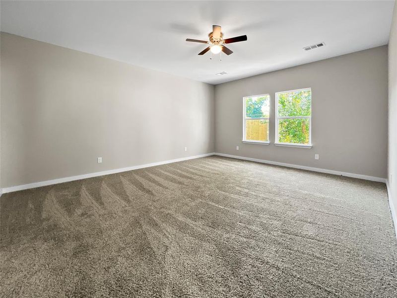 Empty room with ceiling fan and carpet