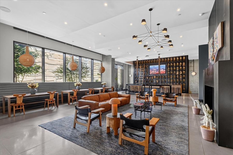 A spacious common area with large windows, a built-in bar, and a mix of seating arrangements for relaxation and socializing.