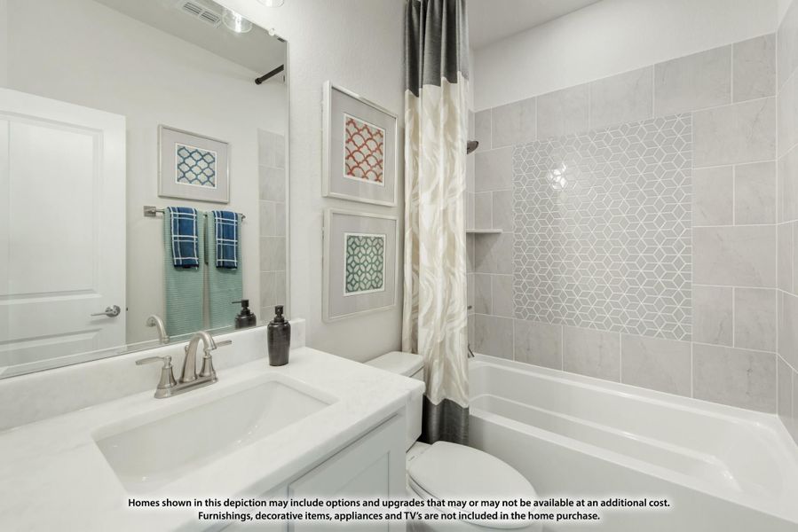 Bathroom with white vanity, large mirror, and tiled shower-tub combo with decorative mosaic accent wall