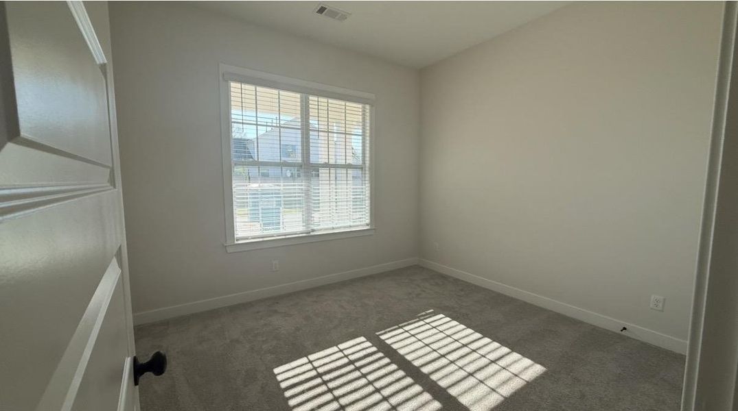 Empty room featuring light carpet and baseboards