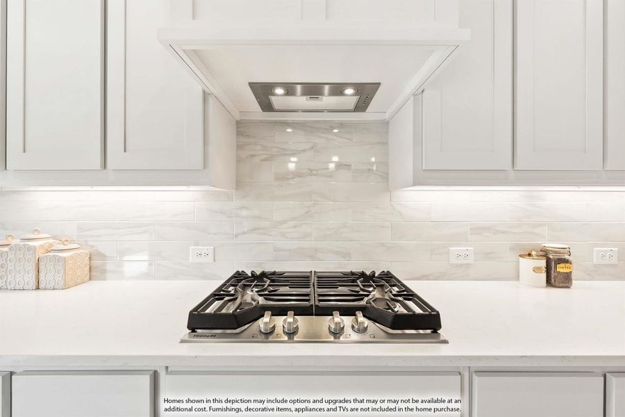 Kitchen cooktop area with stainless steel gas range, white quartz counters, marble tile backsplash, and built-in range hood