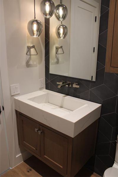 Bathroom featuring decorative backsplash, hardwood / wood-style floors, and vanity