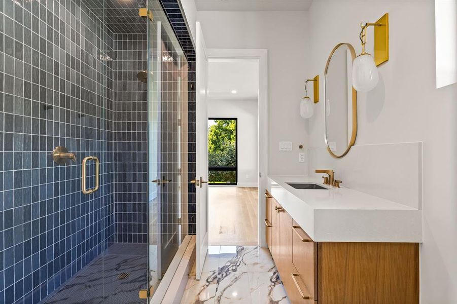 Full bath featuring vanity, a shower stall, and light marble finish floors Full bath featuring vanity, a shower stall, and light marble finish floors