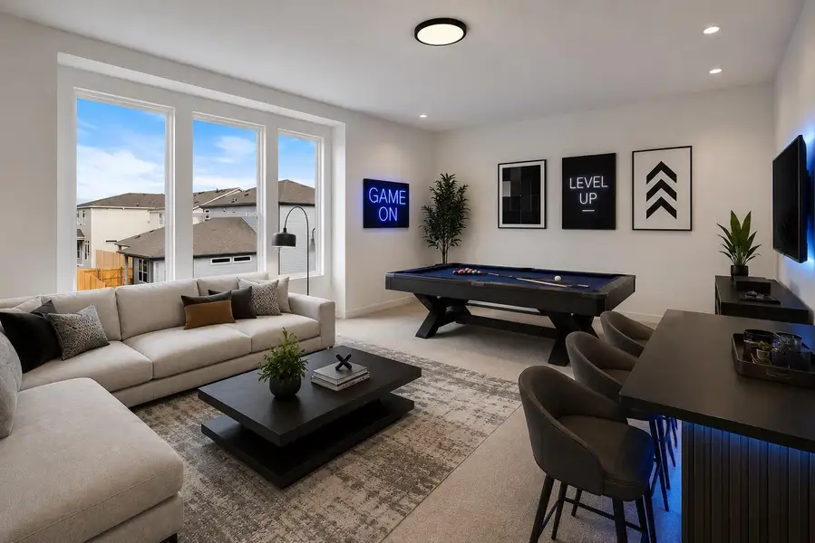 This versatile game room offers ample space for entertaining with a billiard table and comfortable seating.
