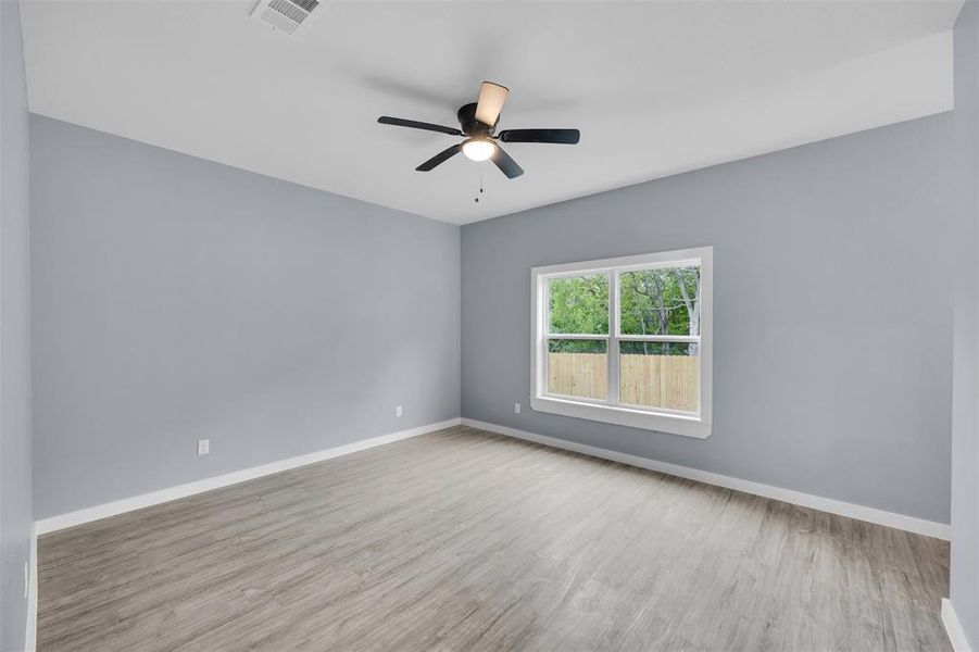 Empty room featuring wood finished floors and a ceiling fan