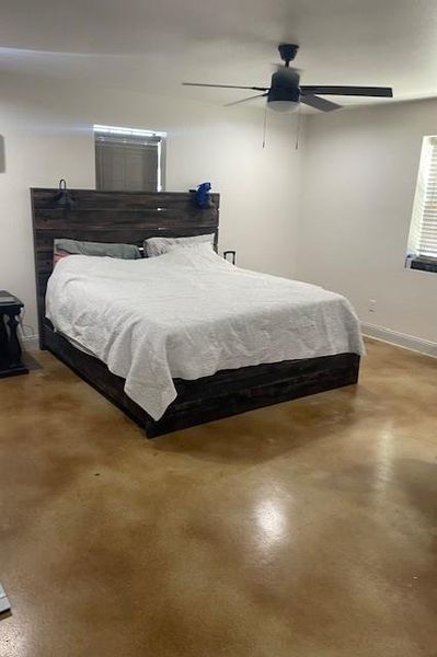 Bedroom with concrete flooring and ceiling fan