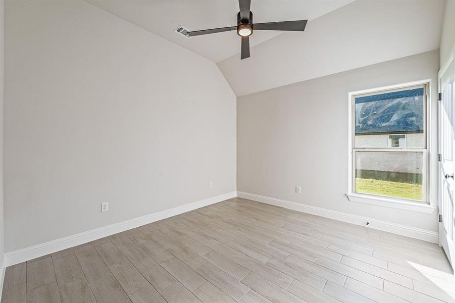 Unfurnished room with light wood finished floors, vaulted ceiling, and ceiling fan