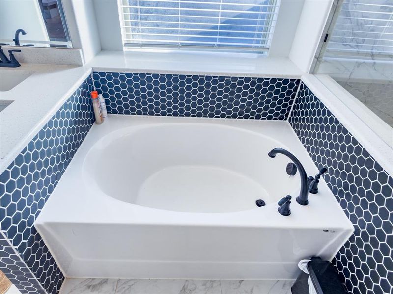Full bath featuring a garden tub and vanity