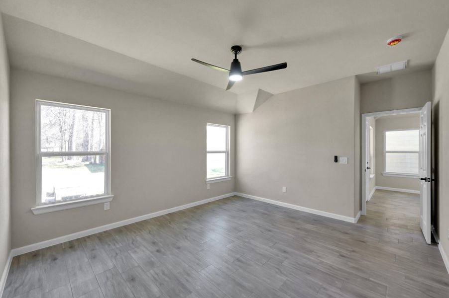 Primary bedroom perspective highlighting the elegant vaulted ceiling and airy atmosphere, creating a perfect private retreat.