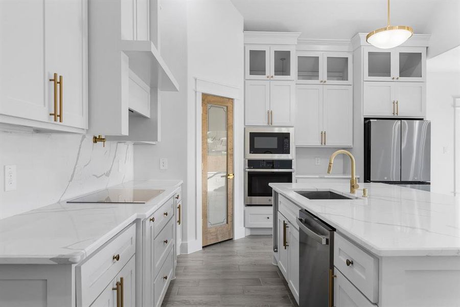 Kitchen with white cabinets, pendant lighting, sink, and appliances with stainless steel finishes