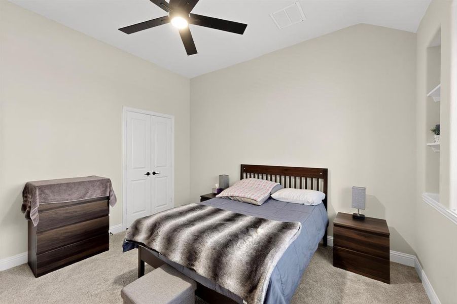 Bedroom featuring light carpet, a closet, a ceiling fan, and lofted ceiling Bedroom featuring light carpet, a closet, a ceiling fan, and lofted ceiling