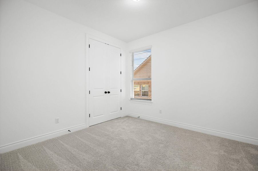 Spare room featuring baseboards and carpet floors