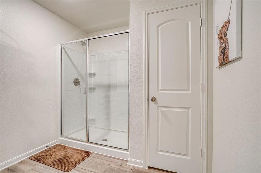 Bathroom with light wood-style flooring and a stall shower