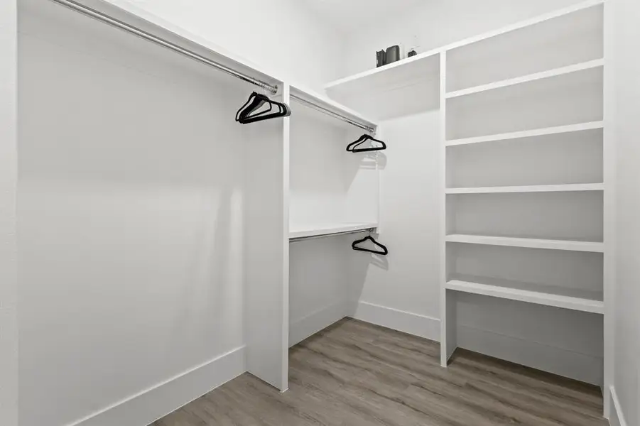 Spacious closet featuring light wood-style flooring