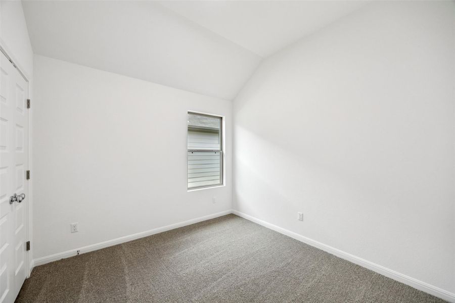 Unfurnished bedroom featuring a closet, vaulted ceiling, and carpet floors Unfurnished bedroom featuring a closet, vaulted ceiling, and carpet floors