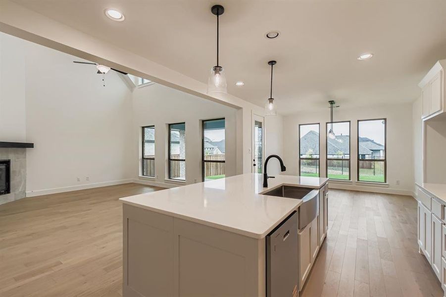 Kitchen with open floor plan, recessed lighting, hanging light fixtures, light wood-type flooring, and white cabinets Kitchen with open floor plan, recessed lighting, hanging light fixtures, light wood-type flooring, and white cabinets