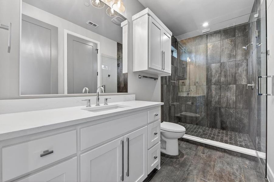 Bathroom featuring a white vanity with a rectangular undermount sink and polished chrome faucet Bathroom featuring a white vanity with a rectangular undermount sink and polished chrome faucet